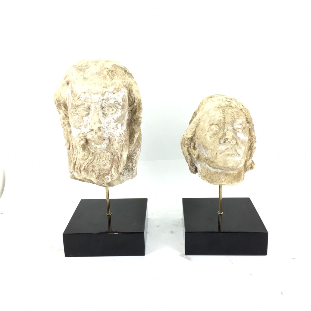 Deux têtes sculptées sur des socles avec tiges laiton