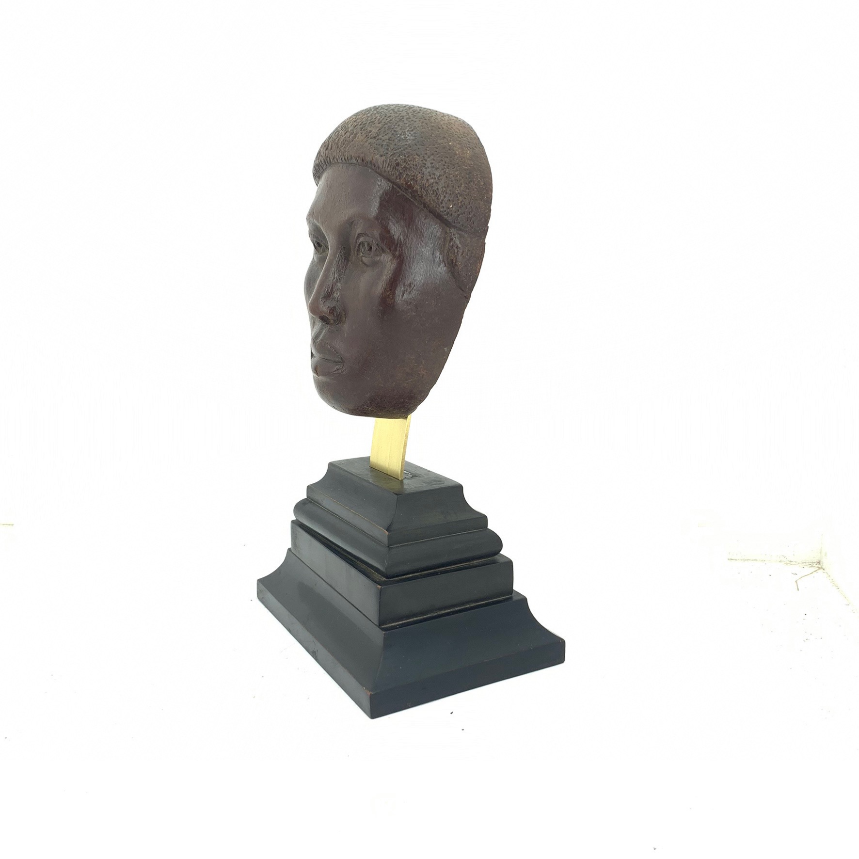 tête sculptée de trois quart sur un socle en bois noir avec doucines  