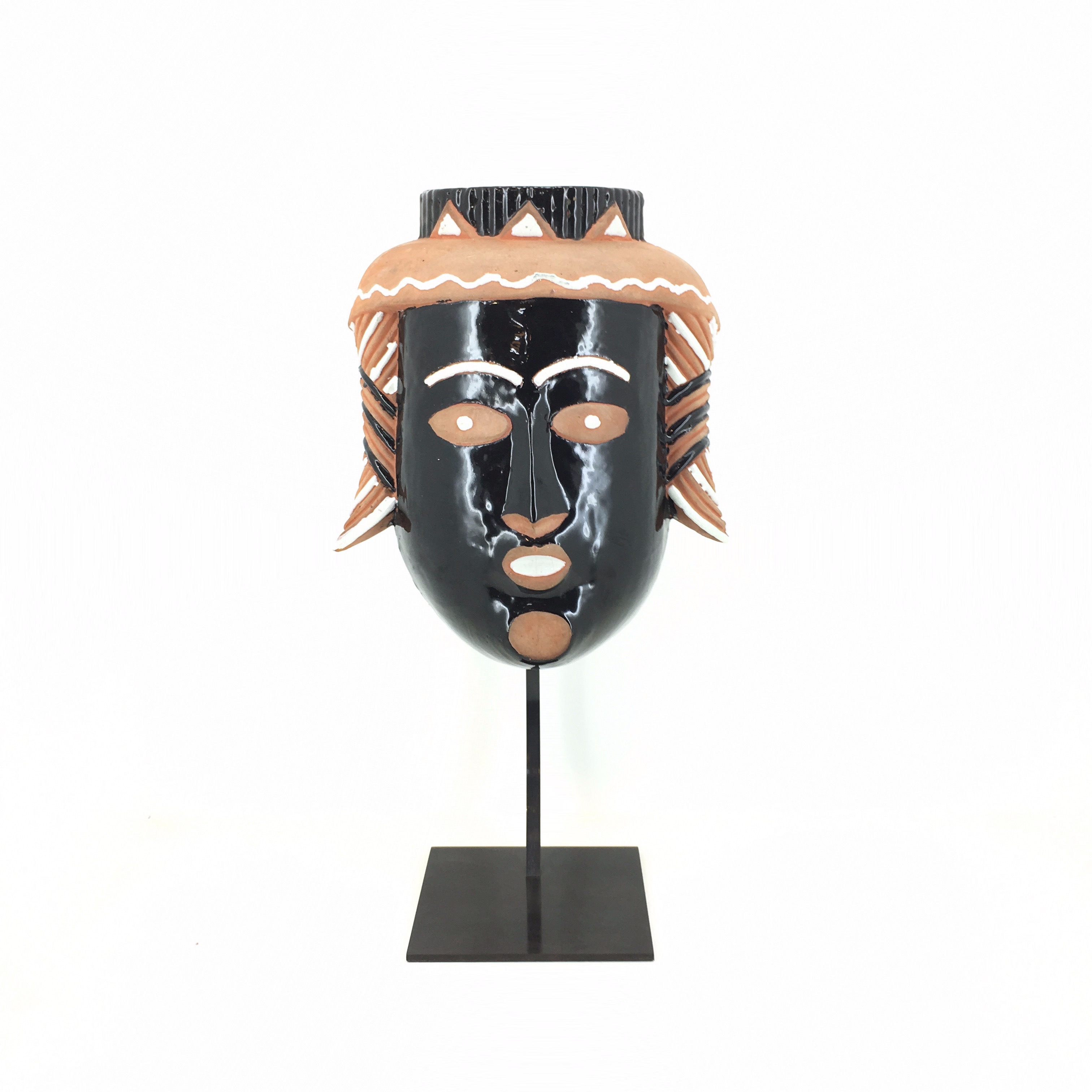 masque en céramique peint sur un socle en acier noir sur fond blanc 