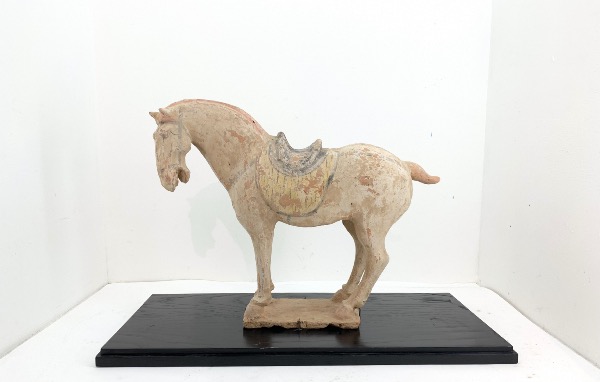 sculpture de cheval en terre sur un socle en bois 